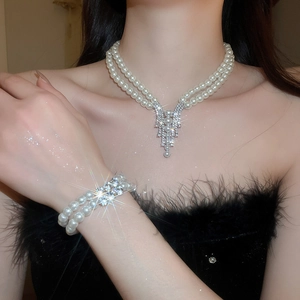 Detail of elegant double-layer pearl necklace and bracelet set with sparkling rhinestone pendant
