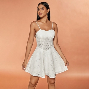 Detailed close-up of the white eyelet lace fabric and corset-style bodice of the mini dress