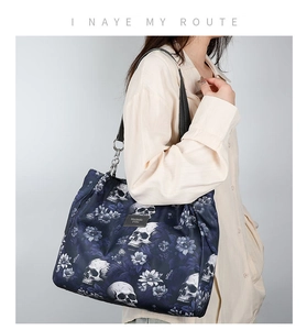 Detail of waterproof nylon shoulder bag with skull and floral print and leather strap