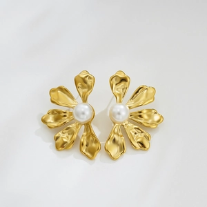 Detailed close-up of matte gold flower earrings with a white center pearl inlay