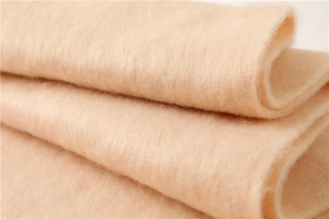 Macro de la texture douce d'une écharpe en mohair rose peau avec de longues franges