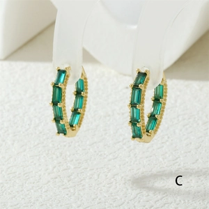 Detailed macro view of 18K gold plated hoop earrings with baguette-cut green zircon stones