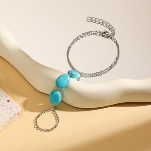 Detailed macro view of silver finger bracelet featuring three turquoise oval stones
