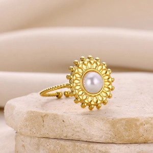 Detail of gold starfish ring with white pearl on porous stone for summer beach style