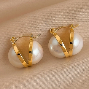 Minimalist gold plated hoop earrings with irregular white pearls on beige silk fabric