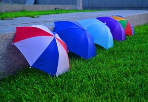 Outdoor detail showing a variety of colorful striped and solid fishing umbrella hats