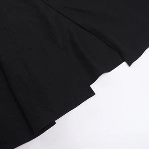Vue macro montrant la texture du tissu noir et les plis de l'ourlet de la robe de vacances