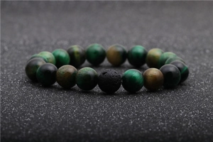 Detailed view of natural green tiger eye beads and black volcanic lava stone on the bracelet