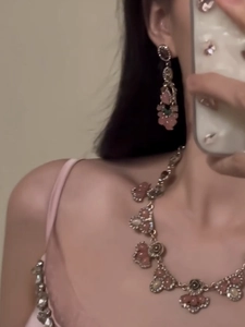 Close-up of vintage pink resin flower jewelry set with sparkling rhinestones on model