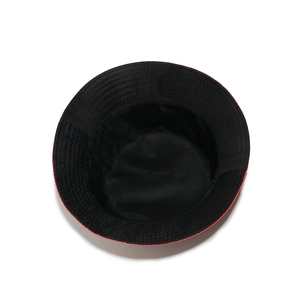 Detail showing the red cotton bucket hat with contrasting black lining and stitching