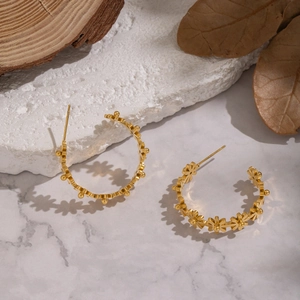 Elegante 18K vergoldete Edelstahl C-Form Blumenohrringe auf Marmorhintergrund