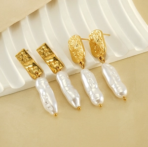 Detail of vintage gold pearl earrings with starburst relief and baroque pearls