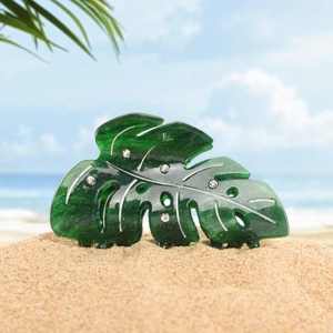 Pince à cheveux feuille de monstera vert foncé avec strass sur fond de plage tropicale