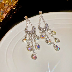 Detail of tassel earrings with silver finish, white pearls and sparkling crystal drops