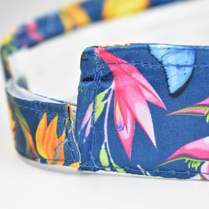 Macro detail of navy satin sun hat with vibrant pink tropical flowers and butterflies