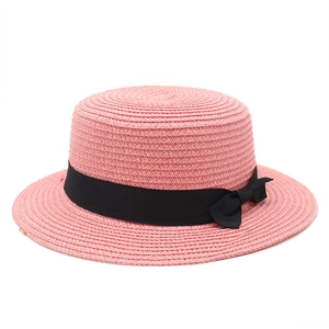 Detail of pink straw boater hat with fine weaving and elegant black grosgrain ribbon bow