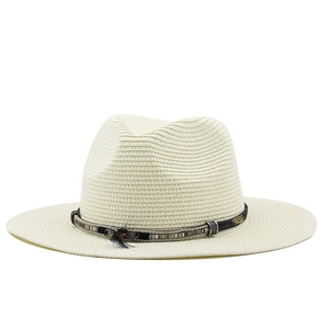 Close-up of woven straw fedora hat featuring a contrast band and delicate feather detail