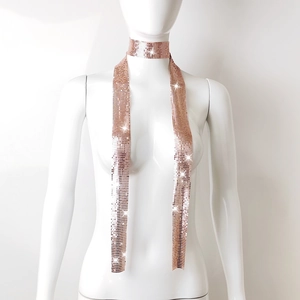 Detail of rose gold metal mesh scarf featuring shimmering sequins on a white mannequin