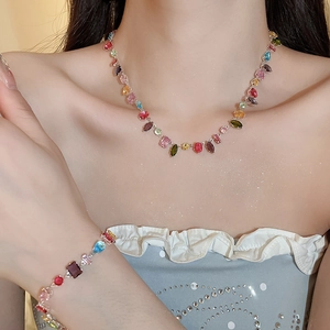 Detailed view of colorful zircon geometric necklace and bracelet set on a model