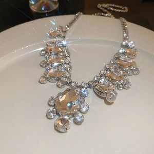 Detailed macro view of sparkling pear-shaped crystal pendant on a silver tassel necklace