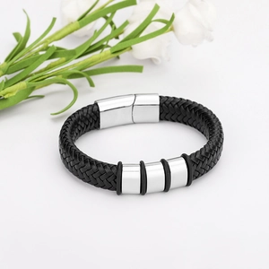 Geflochtenes Lederarmband mit Edelstahl-Magnetverschluss und Metallringen auf weißem Grund