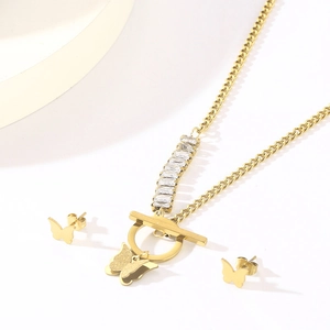 Detailed view of golden butterfly necklace and earrings set with inlaid crystals
