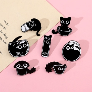 Set of seven playful black cat enamel pins in various poses on a pink background