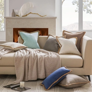 Detail showing various solid colored linen pillow covers with woven jute rope trimming