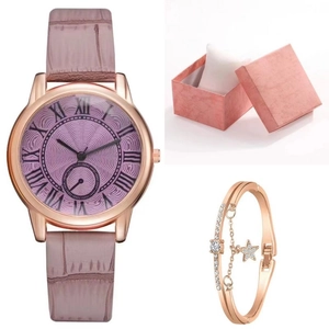 Detalle de reloj de oro rosa con pulsera de estrella en una caja de regalo rosa