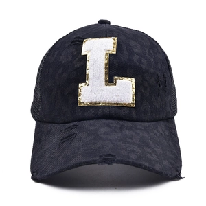 Detail of vintage baseball cap with sequined letter L and breathable mesh back