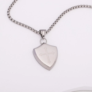 Detailed close-up of a silver shield pendant featuring a cross design with arrow accents