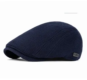 Gros plan détaillé d'une casquette plate bleu marine avec texture gaufre et logo métal