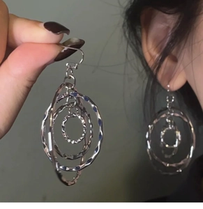 Detail of silver layered hollow hoop earrings with textured finish and ear hook
