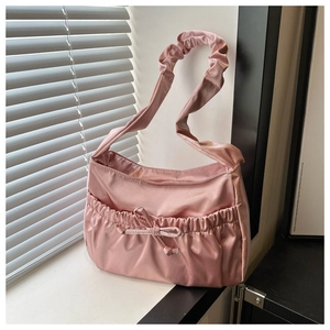 Detail view of pink satin shoulder bag showing drawstring cloud pleats and bow detail