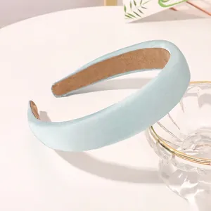 Detail of light blue satin sponge headband with brown anti-slip inner lining texture