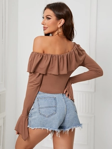 Top marrón con hombros descubiertos y volantes con pantalones cortos vaqueros azules