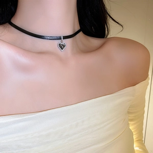 Close-up of black ribbon choker featuring a sparkling crystal heart-shaped pendant