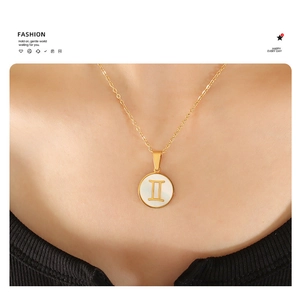 On-model view of 18K gold Gemini constellation necklace with white shell pendant