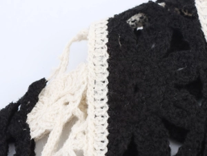 Makroaufnahme des französischen Retro-Häkeloberteils mit schwarz-weißem Hohlstrickmuster