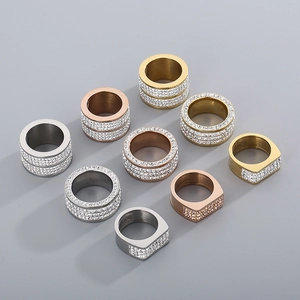 Detailed view of stacked hip hop style rings in gold, rose gold and silver with zircon