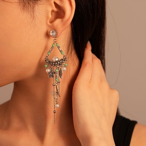 Close-up of vintage silver earrings with leaf and butterfly charms on model