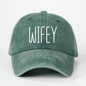 Close-up of washed green cotton baseball cap with white WIFEY printed text detail