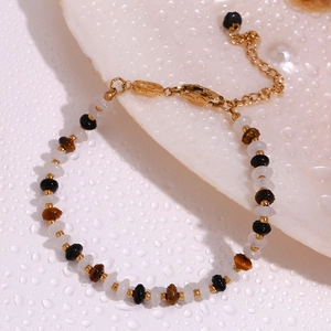Detail of 18K gold-plated beaded bracelet with tiger eye and white chalcedony stones