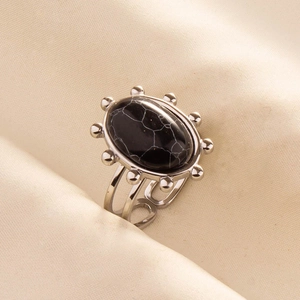 Detailed view of bohemian stainless steel ring with oval black stone and marble texture