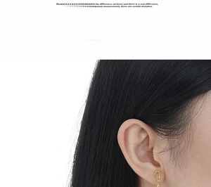 Close-up of minimalist gold teardrop earring with an asymmetric organic shape design