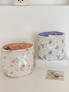 Detalle de cestas de almacenamiento acolchadas con motivos de osos, flores y encaje