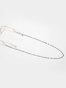 Detailed view of golden eyewear chain featuring delicate black heart-shaped beads detail