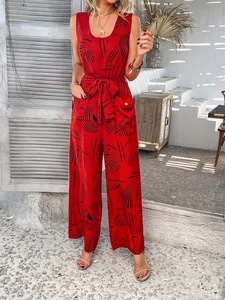 Detail of red sleeveless wide-leg jumpsuit with black abstract print and waist tie