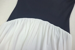 Detail of waist stitching, knit fabric texture and pleated chiffon hem in navy and white