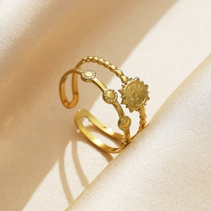 Anillo abierto de doble capa dorado con dijes de sol y flores sobre seda